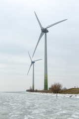 Large windmills on a dyke of the frozen Gouwsea near the village of Uitdam.