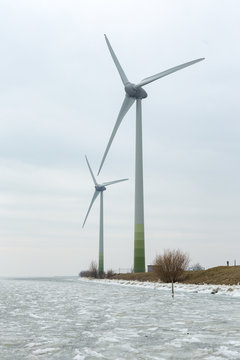 Large windmills on a dyke of the frozen Gouwsea near the village of Uitdam.