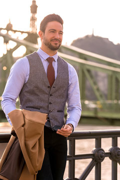 An elegant man standing next to a river