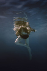 Fototapeta na wymiar Portrait of a girl swimming underwater