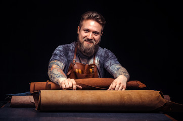 Worker of leather creating new leatherwork at his leather studio