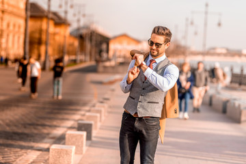 An elegant man walking on the streets and checking the time