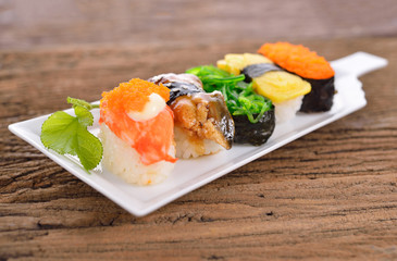 Sushi Set nigiri and sashimi served in long white plate on wooden background