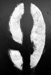 Number 9 in stencil on metal wall in black and white.