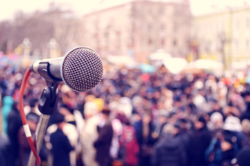 abstract image with a microphone on the background of a crowd at a rally