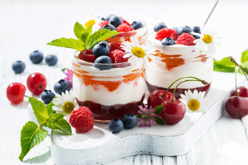 sweet dessert with jam and cream on white wooden board, closeup
