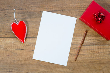 Mockup romantic postcard with felt heart and red giftbox. Flat lay with copy space for text