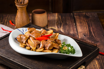 Braise pig's large intestines in soy sauce in a white ceramic dish