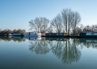 Canal boat moored on side of a canal on spring morning