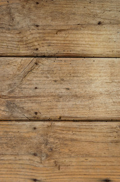 Vertical background of weathered wooden planks with nails and streaks. Texture of old and big wooden boards of light brown colors.