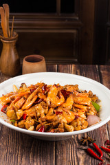 Fried spicy bullfrog and chicken with chilli in a white ceramic dish
