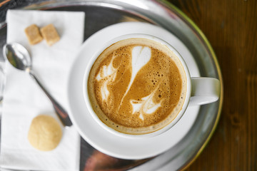 Cup of hot coffee latte on a wooden table