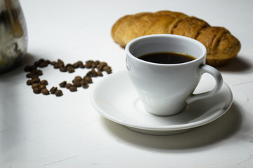 Coffee cup croissant and heart of coffee bean