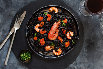 Squid ink pasta with prawns and tomatoes