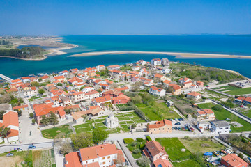 Fototapeta na wymiar Aerial view of city of Nin. Summer time in Dalmatia region of Croatia. Coastline and turquoise water and blue sky with clouds. Photo made by drone from above.