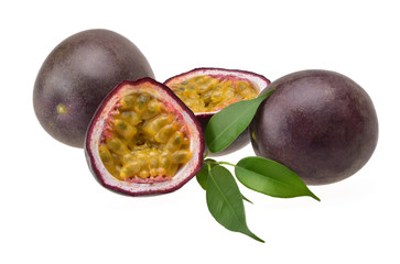 Two purple passion fruit and two halves with ripe yellow flesh with refreshing green leaves on a neutral white background