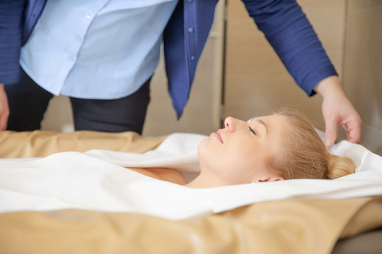 young beautiful woman are doing a fango therapie in a wellness area. friends are on the side of the water bed