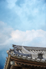 Antique Japanese buddhist temple showing roof structure; gable and tiles against the bright sky...