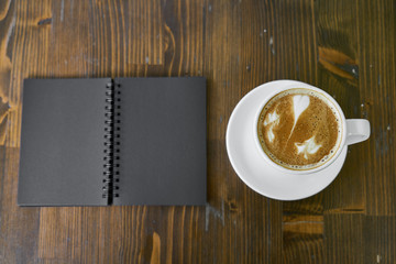 Cup of hot coffee latte on a wooden table