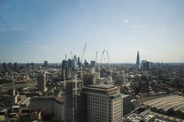 Wide angle shot of London Buisness, skyscraper distrcit from a birdview with cranes and construction, that was approved by the government or the council.