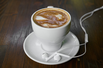 Cup of hot coffee latte on a wooden table