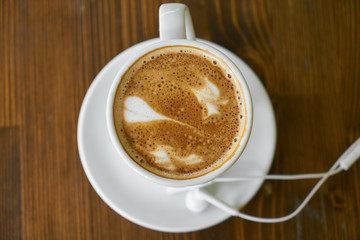 Cup of hot coffee latte on a wooden table