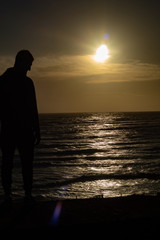 silhouette of man on the beach at sunset