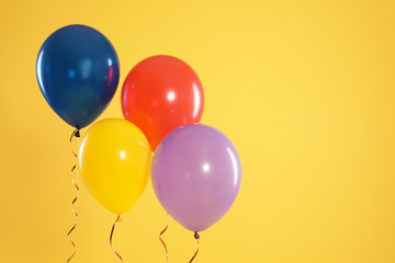 Bright balloons on color background, space for text. Celebration time