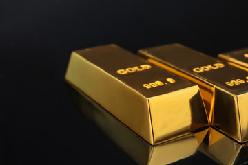 Shiny gold bars on black background, closeup. Space for text