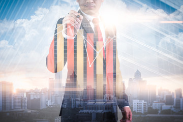 The double exposure image of the businessman point to business chart overlay with cityscape image. The concept of modern life, business, city life and internet of things
