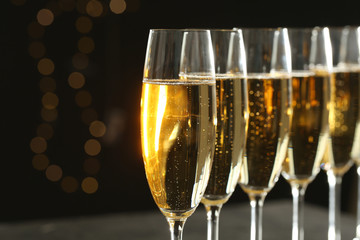 Glasses of champagne on blurred background, closeup. Space for text