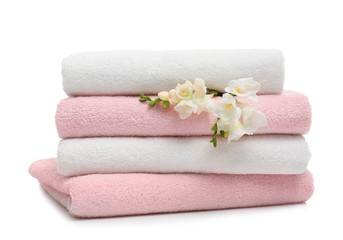 Obraz na płótnie Canvas Stack of clean folded towels with flowers on white background