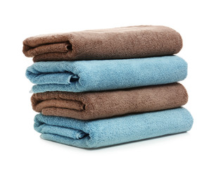 Stack of clean folded towels on white background