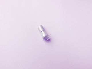 Violet nail polish bottle on monochrome background