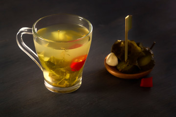 Glass with cucumber pickle on a wooden table. Close-up