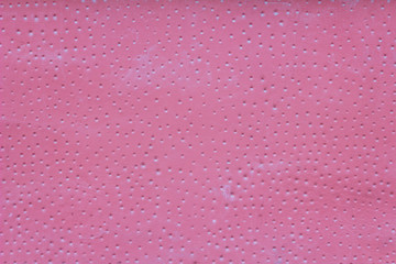 pink wall with scratches, small white round holes with shadows and paint stains. rough surface texture