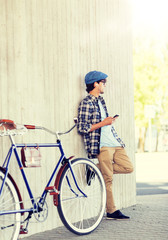 Fototapeta premium people, communication, technology and lifestyle - hipster man with smartphone, earphones and fixed gear bike listening to music on city street