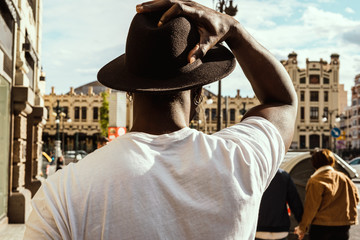 Guy with hat dressed in style and modern in the city. African american guy