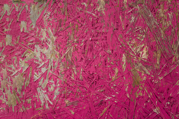 bright pink fiberboard with battered paint. rough surface texture