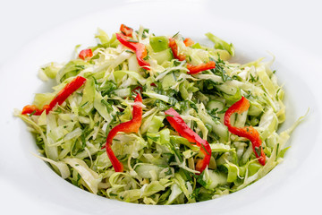 Salad with fresh cabbage and cucumber. On white background
