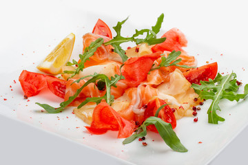 Sliced fish, salmon and perch with arugula and tomatoes. On white background