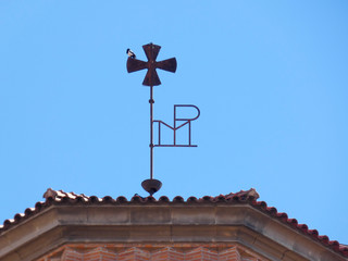 Fototapeta na wymiar Pájaro posado en la cruz de la catedral de Sant Feliu de Llobregat