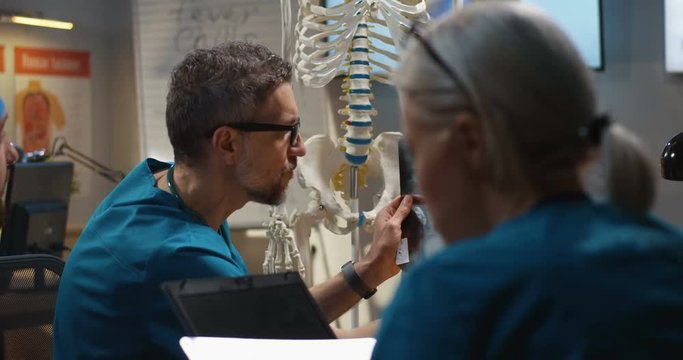 Doctors examining cervical spine x-ray