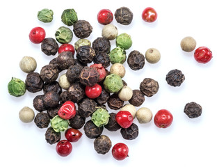 Black, white, green and red peppercorns isolated on white background.