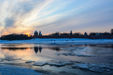 Veliky Novgorod. Kremlin. A beautiful winter sunset over the Kremlin with reflection in the river and ice floes in the foreground.