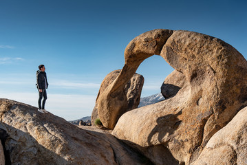 Asian man tourist looking through the mobius arch stone at Alabama Hills, Lone pine, USA. Travel...