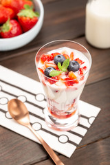 Healthy sweet dessert in glass with strawberries, yogurt and blueberries