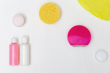 Accessories for cleansing skin, electric brush, cosmetic sponge, moisturizer, cleanser. Beauty and skincare concept. Flat lay. Top View.