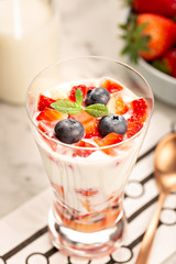 Healthy sweet dessert in glass with strawberries, yogurt and blueberries