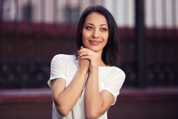 Happy young fashion woman in white t-shirt on city street